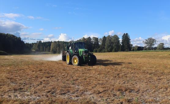 A tractor applying gypsum on a field